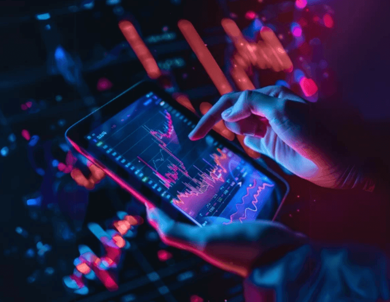 Hands on a tablet showing crypto price charts in neon light