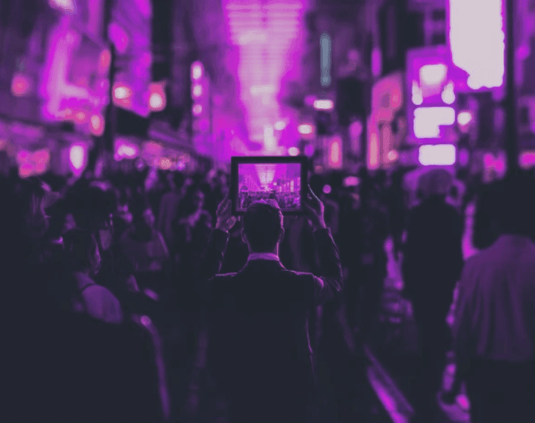 A crowd on a neon-lit street filming with a tablet