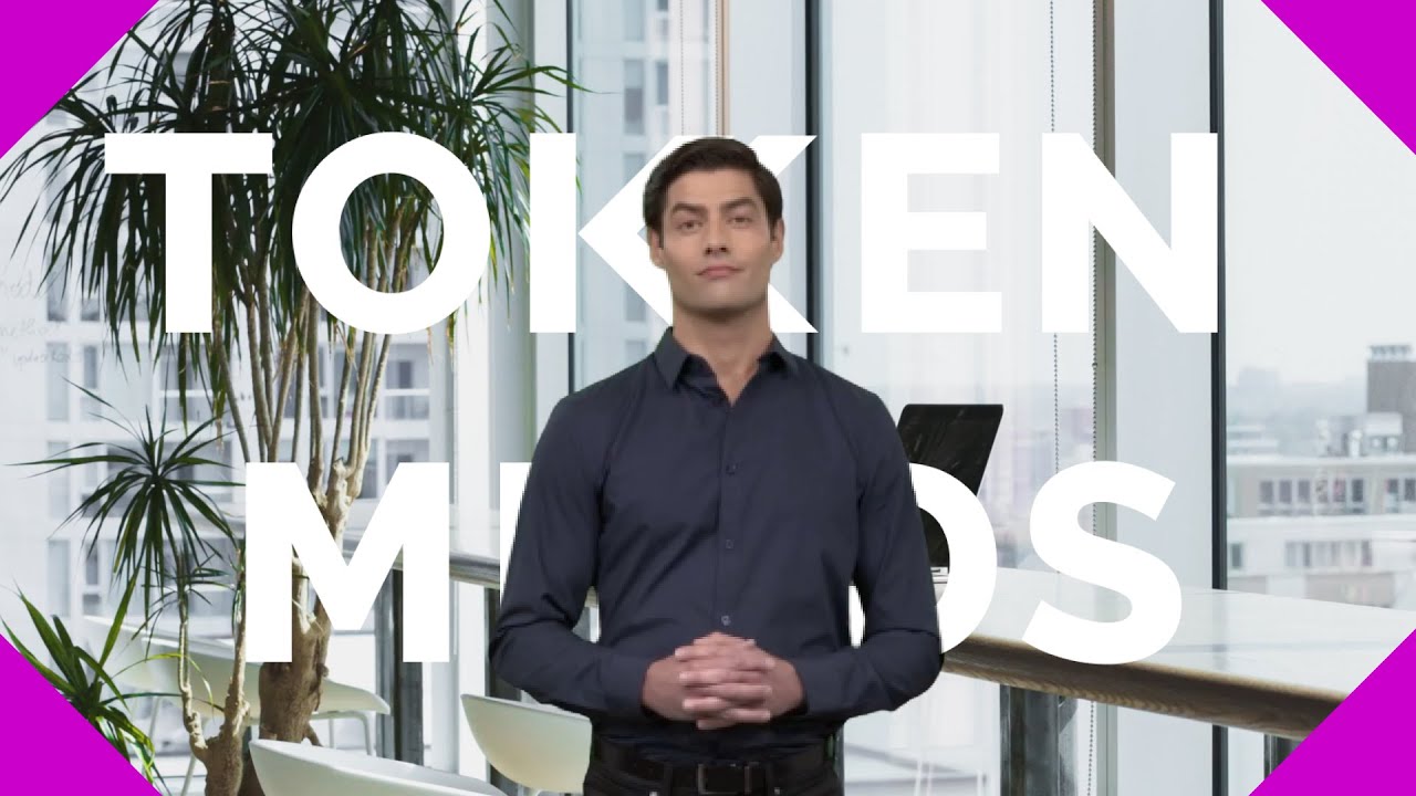 A presenter in an office in front of the TokenMinds name