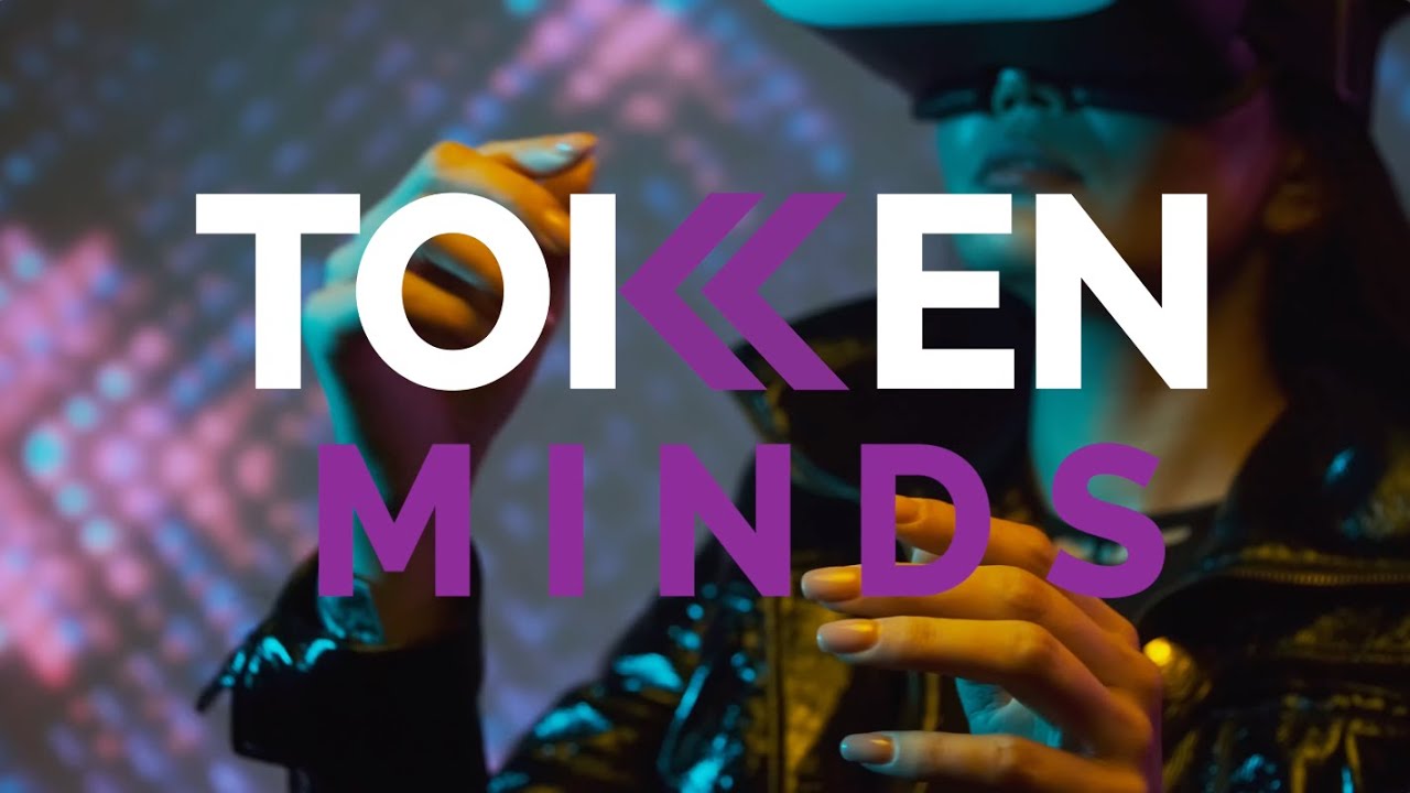 The TokenMinds logo over a woman in a VR headset reaching out with both hands, coloured lights behind her